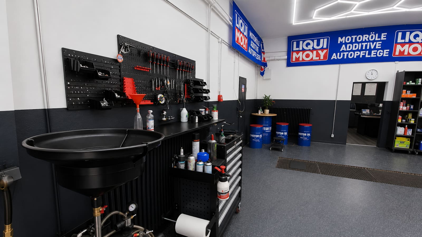 Arbeitsplatz mit Werkzeugwand und Liqui-Moly-Ölfässern